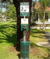 Sign with Pet Waste Disposal instructions above a bag dispenser and trash receptacle